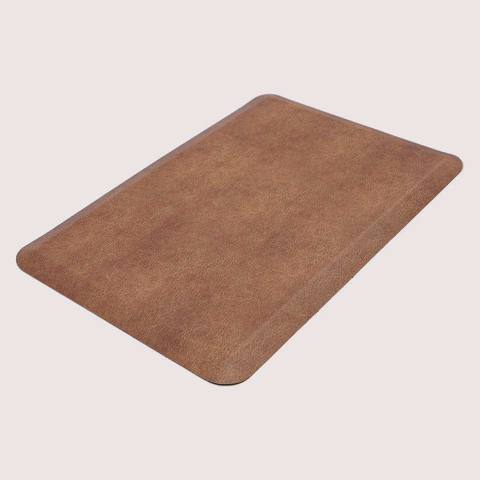 Angled image of the comfortable Leather anti-fatigue mat, with its waterproof, wipeable surface, and beveled edges