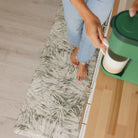 Happy Feet's misty Tranquil Palms mat in a kitchen by the coffee maker for easy clean up.