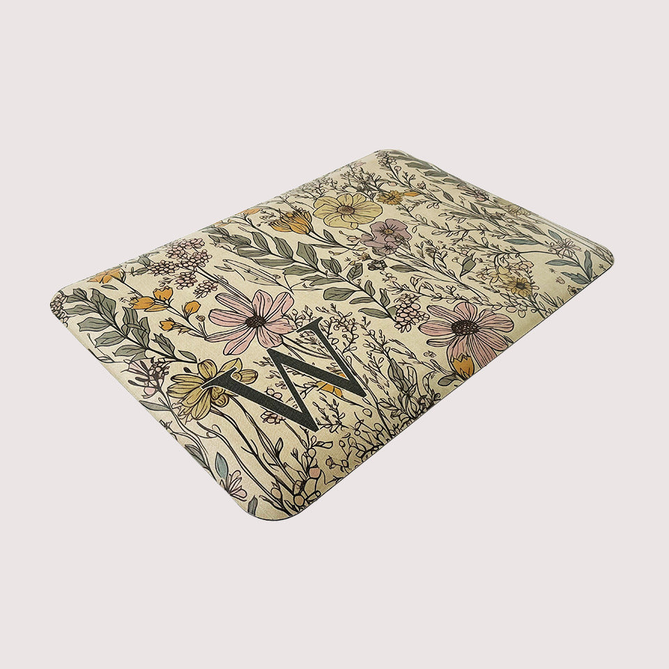 Wildflowers Monogrammed anti-fatigue mat on a light beige, canvas-liked textured background, with a wipeable surface.