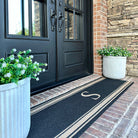 Low-profile Initial Stripes coir on black double door indoor mat monogrammed with the letter S.