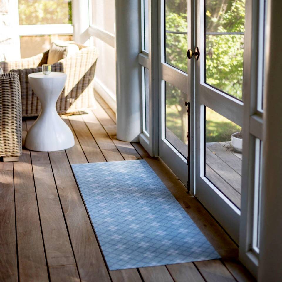 Un-Rug Sea Salt blue plaid interior low profile rubber backed floor mat in diamond pattern is placed just inside a set of screen double doors on a back porch.