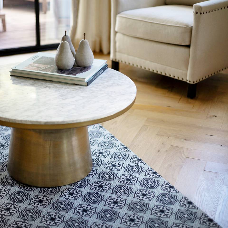 Beautiful low-profile Un-Rug in classic porto geometric architectural design in navy and sea salt green being used as a decorative area rug that protects floor from furniture scratches.