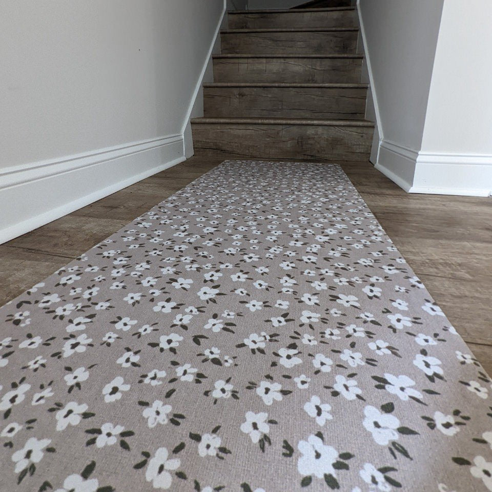 Un-Rug durable rubber backed accent rug is a low-profile decorative mat that provides floor protection in high traffic areas and is shown at the base of indoor stairs.