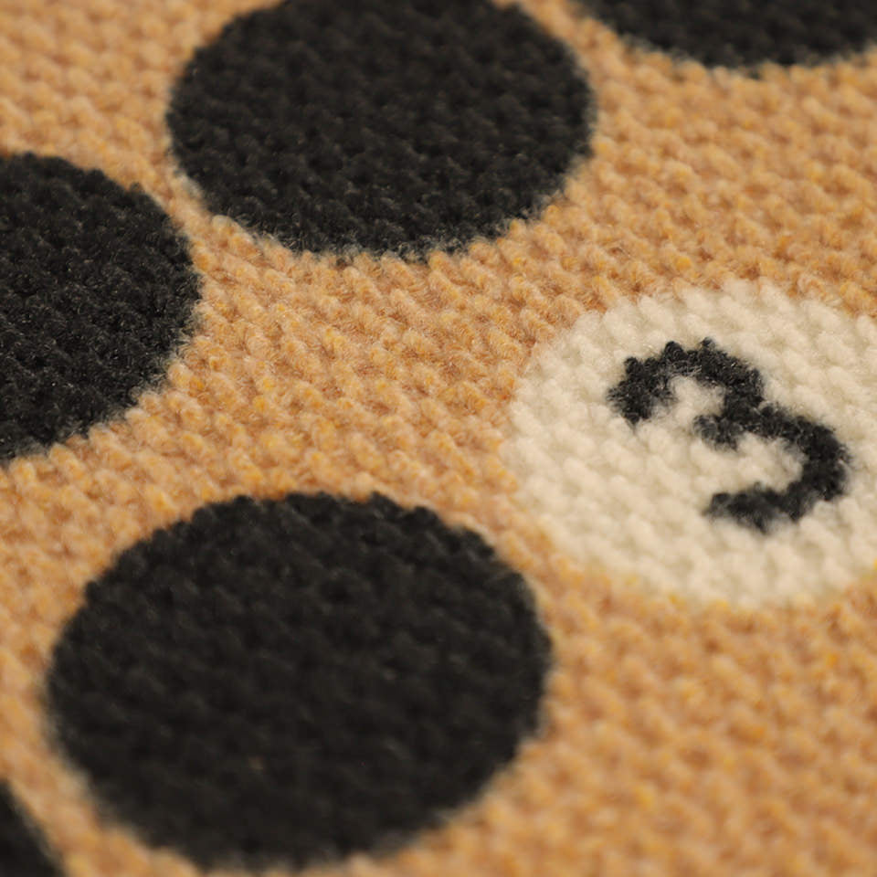 Detailed shot of Lucky Numbers non shedding surface in black, white, and coir.