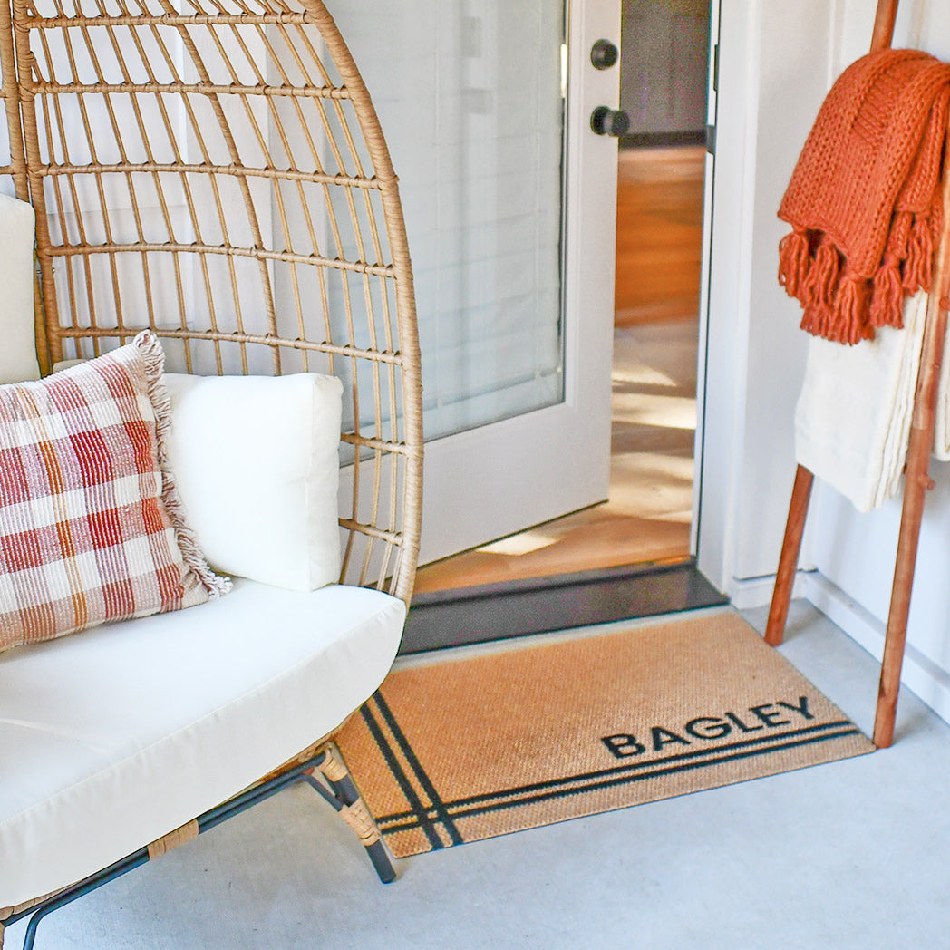 Neighburly Hashtag doormat personalized with the last name Bagley at an entrance of an opened side door. 