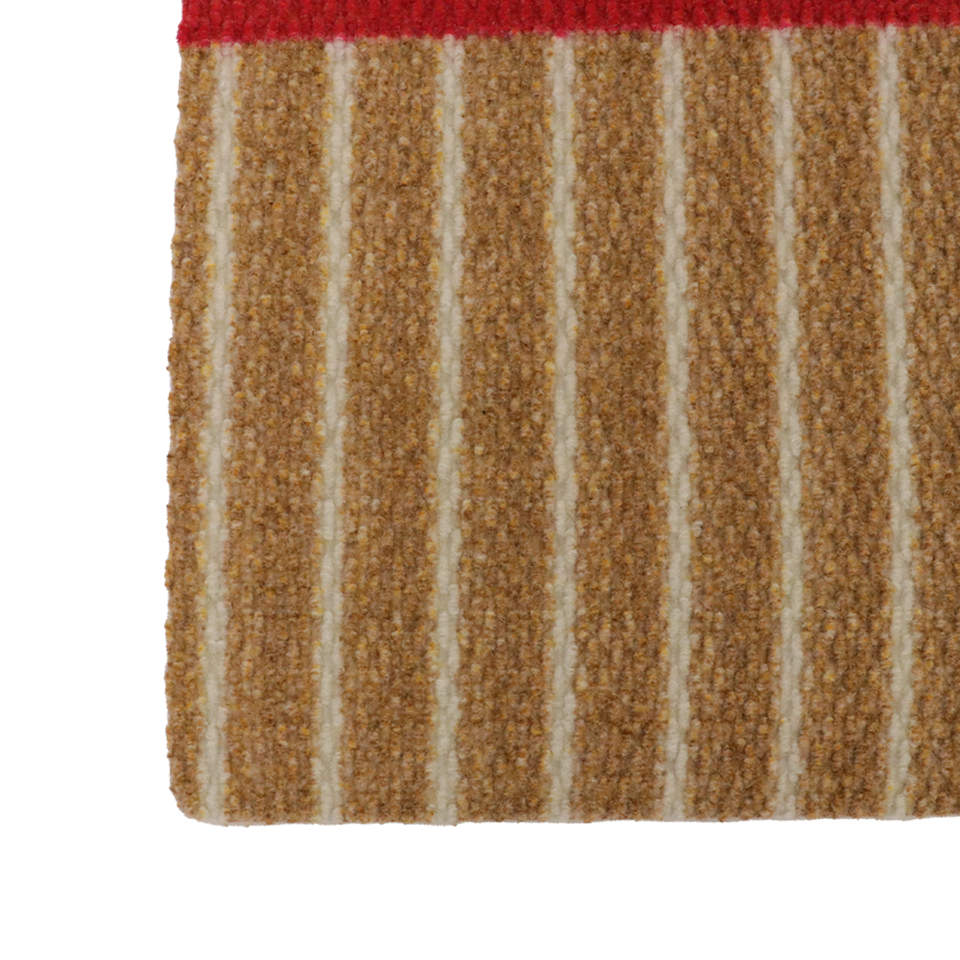 Unique Christmas themed door mat that looks like a brown and white striped present with red bow and rounded corners.