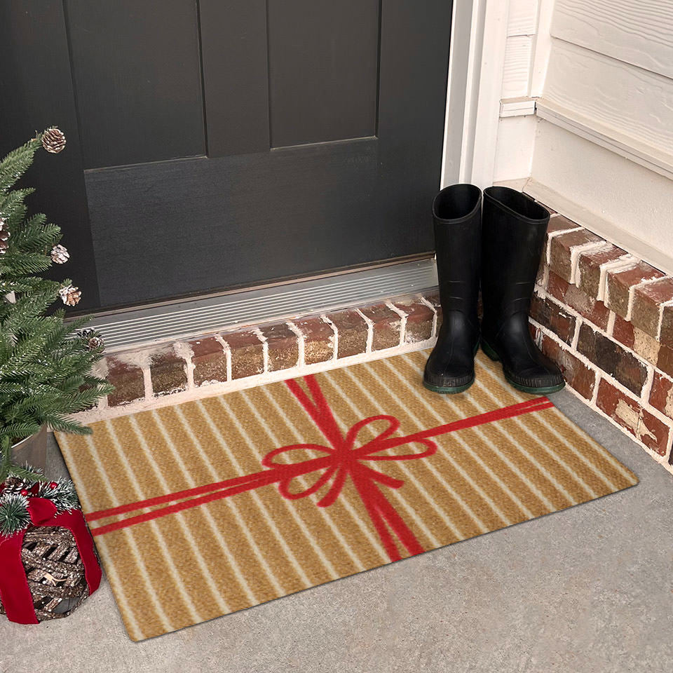 Unique Christmas themed door mat that looks like a brown and white striped present with red bow elevates the look of a decorated front porch.