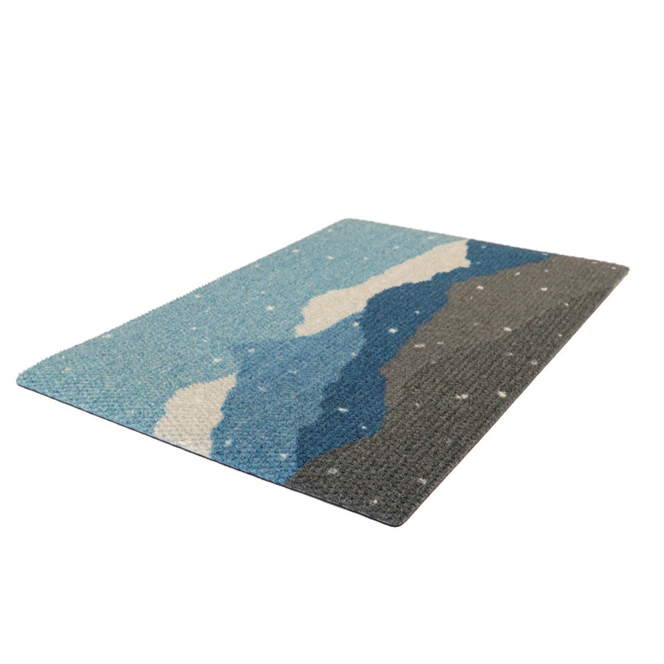 Beautiful wintery landscape holiday door mat; featuring durable rubber backing and recycled plastic surface.