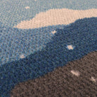 Beautifully textured surface of wintery landscape welcome mat; featuring snowy mountains in shades of blues, greens, and white.