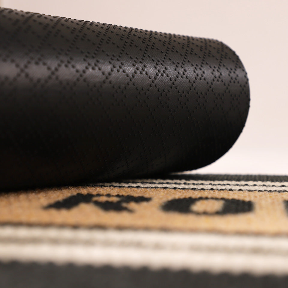 Image of the rubber backing rolled up on Modern Moniker’s non-shed personalized black, white, and coir surface.