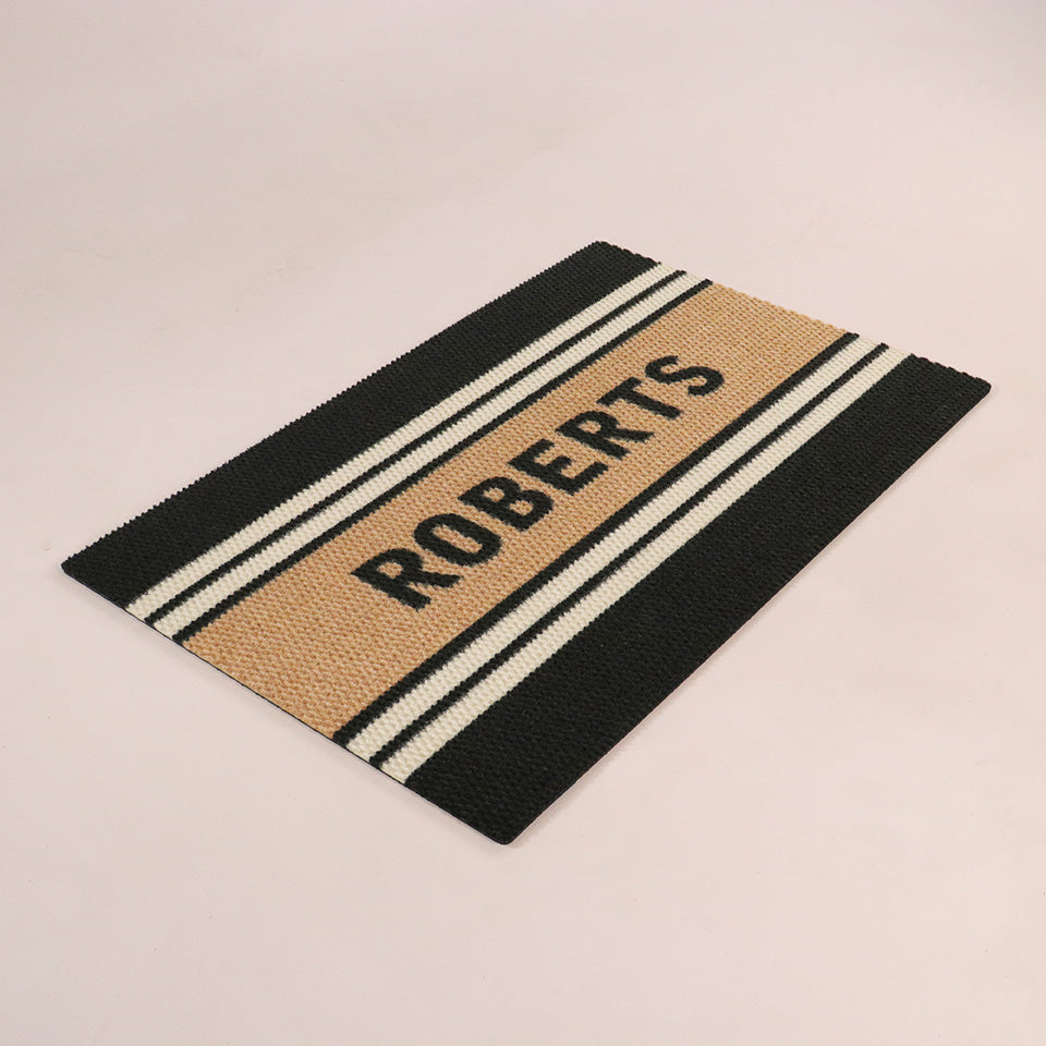 Angled single door Modern Moniker mat personalized with a last name on a coir stripe with multiple stripes on black background.