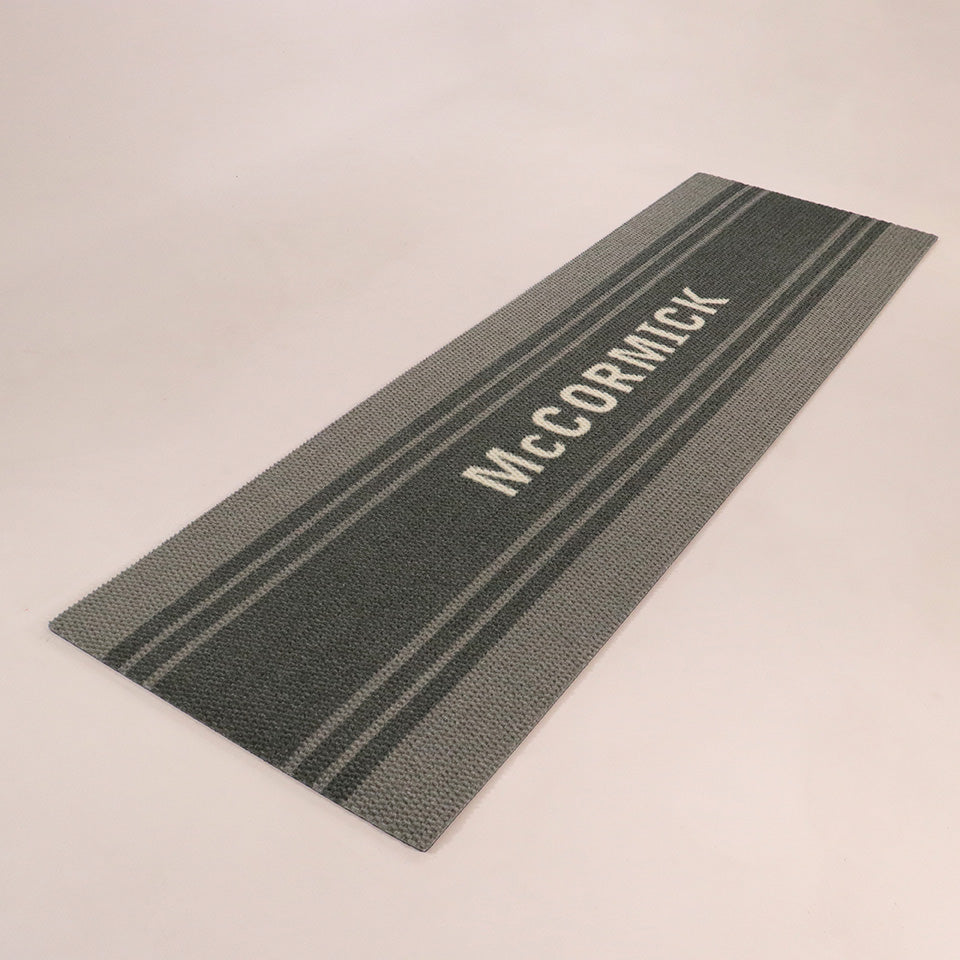 Angled double door Modern Moniker mat personalized with last name on a grey mat with grey stripes.