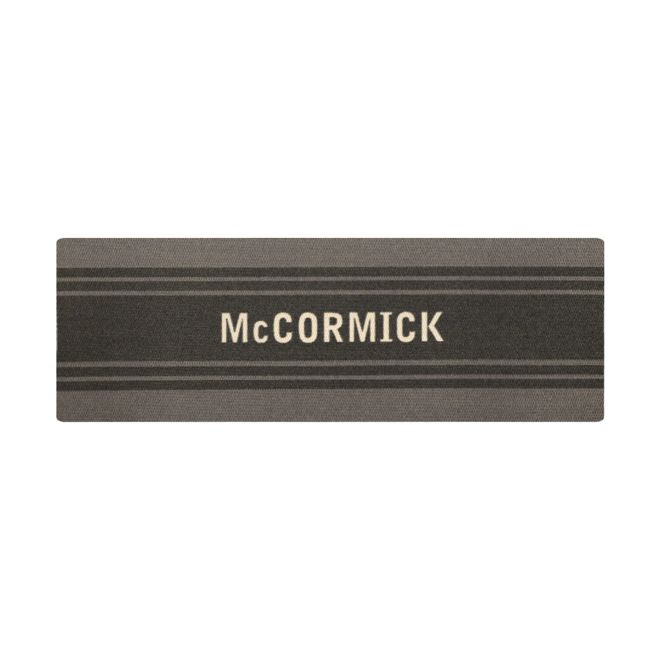 Overhead of double door Modern Moniker mat, personalized name on dark grey bar with two  lines on a grey background.