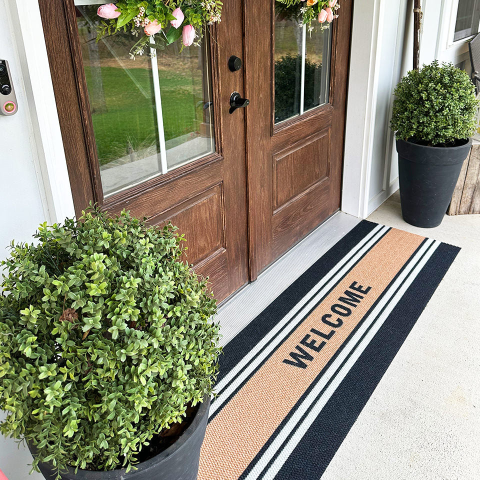 Overhead angle of Modern Moniker personalized welcome mat in double door that is American made.