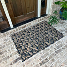 Large doormat for single door that extends slightly past the edges, with a repetitive floral design