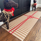 Neighburly's Brown Paper Package double door entrance mat with white stripes on coir wrapped in a red bow.