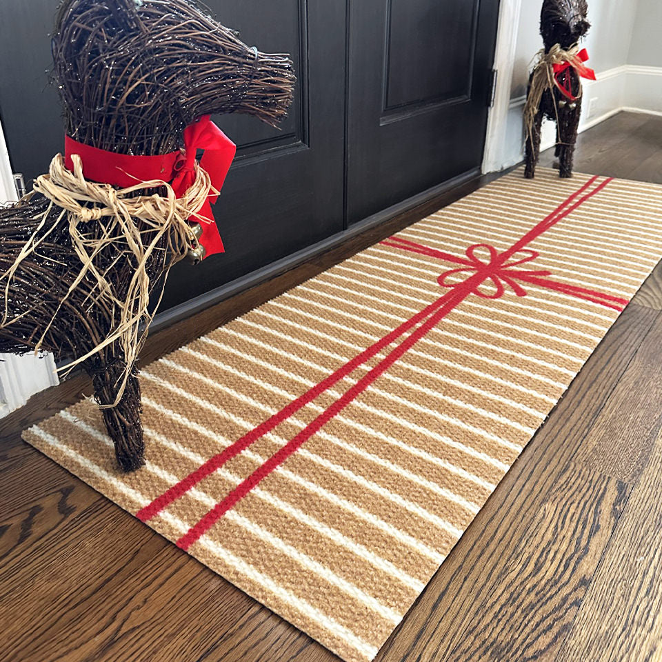 Neighburly's Brown Paper Package double door entrance mat with white stripes on coir wrapped in a red bow.