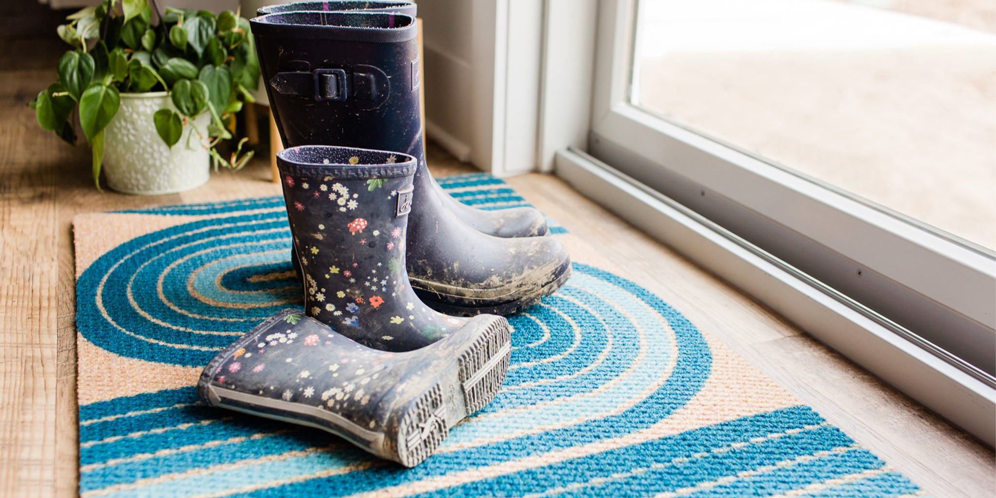 Two pairs of dirty boots on top of a Retro Vibe double doormat