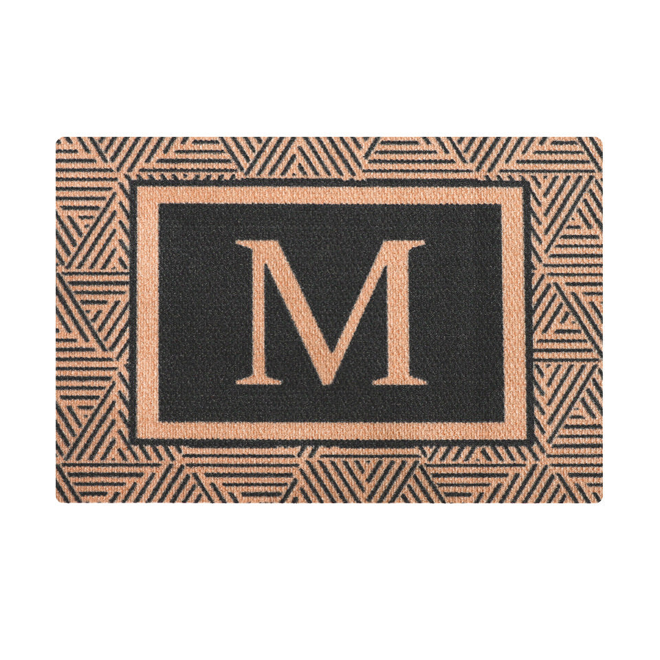 Upscale modern monogrammed doormat; the Escher Monogrammed decorative doormat is an elegant entry mat featuring a modern geometric design in brown and black.