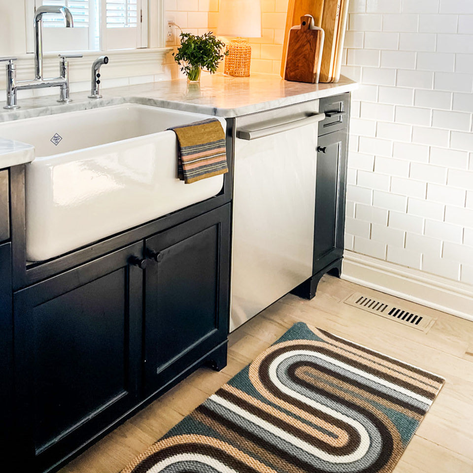 Stylish and durable Neighburly Retro Vibes decorative doormat is placed at the base of a kitchen sink to protect floors from water and moisture.