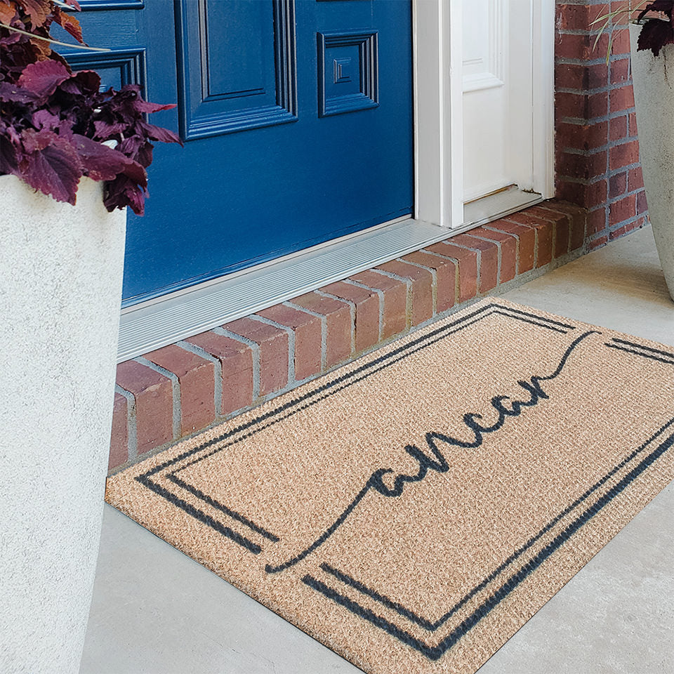 Single door Surname Script doormat on a tan mat with a black box with a last name in script in the center.