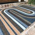 Multicolored striped doormat of greys, browns, and white that doesn't shed