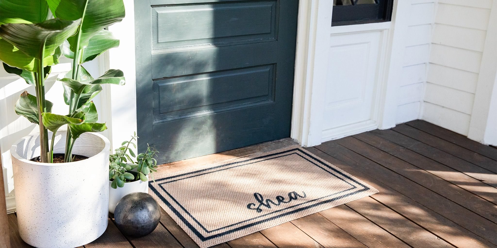 Personalized Neighubrly Around The Block single door mat with black text on a tan background in front of a closed door.