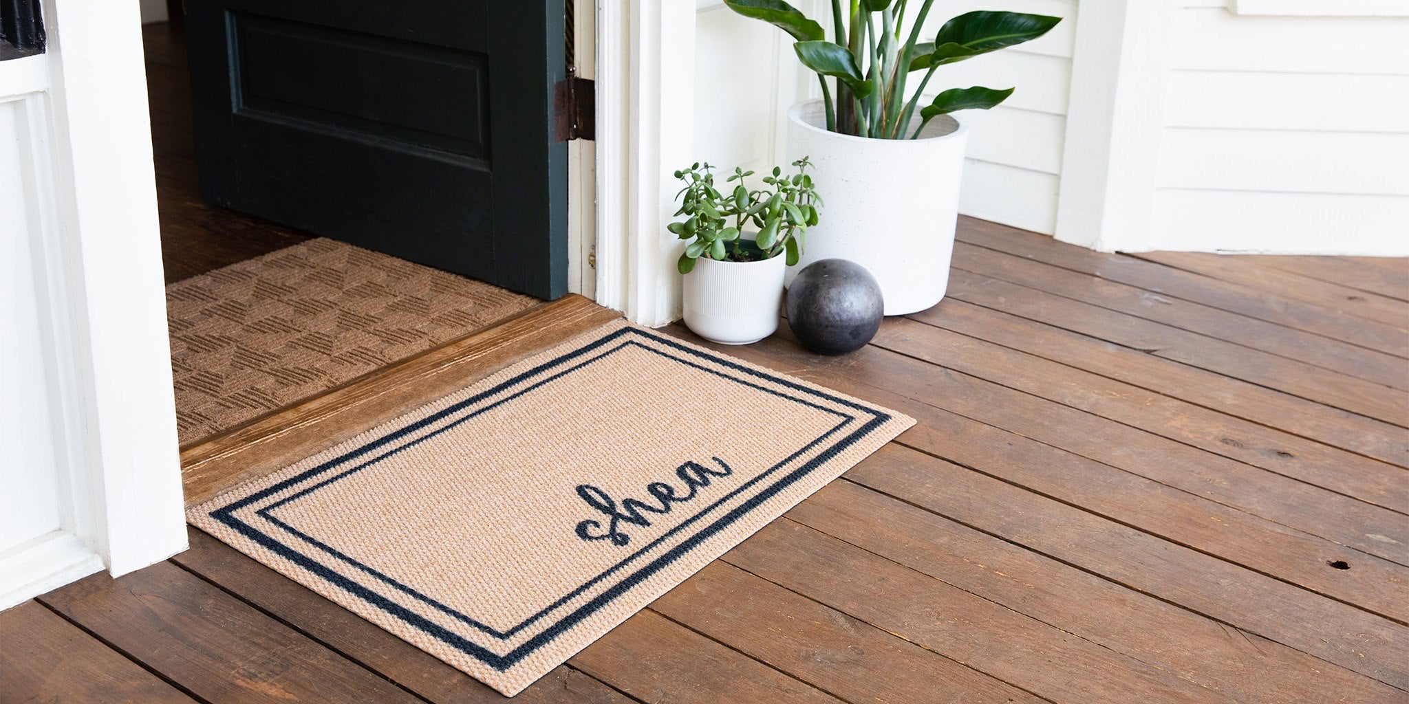 Neighburly Personalized Around Town doormat pair with a WaterHog Luxe Labyrinth doormats at the front door at a home.