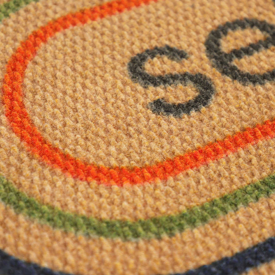 Detailed shot of Rainbow Roundabout’s non shedding surface and vibrant colors on a coir background.