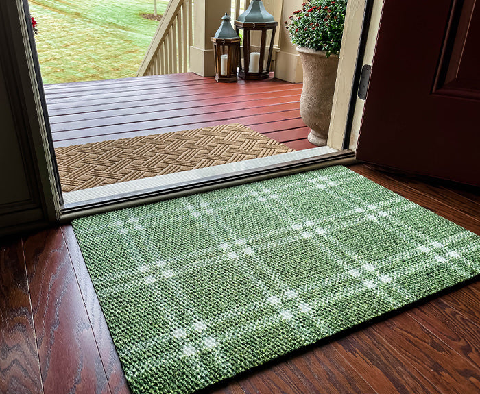 Green plaid doormat at front door paired with wheat colored outdoor doormat