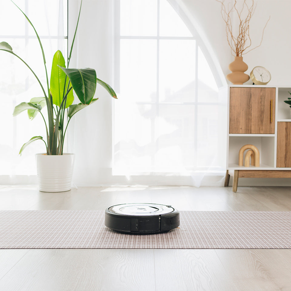 A robot vacuum running overtop of an the Bouncle Weave with no snags or catches because it is so low-profile