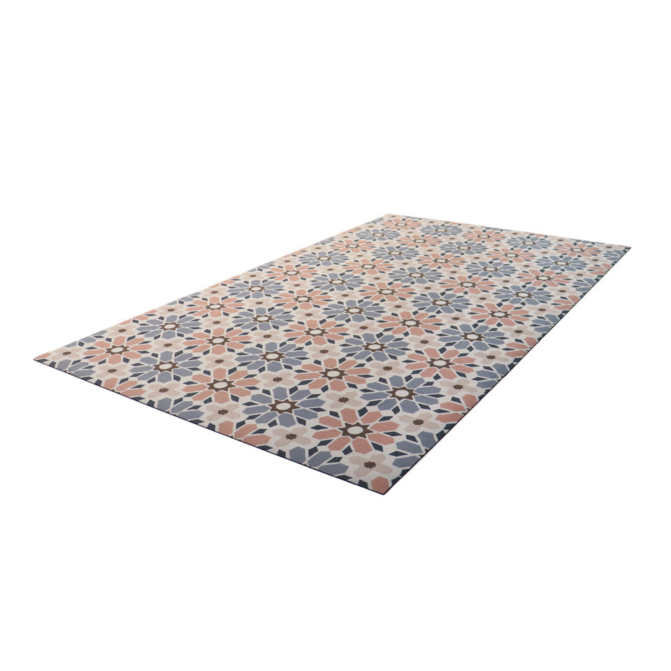Angled overhead shot of Moroccan tiled low profile indoor floor mat in pinks, blues, and beige