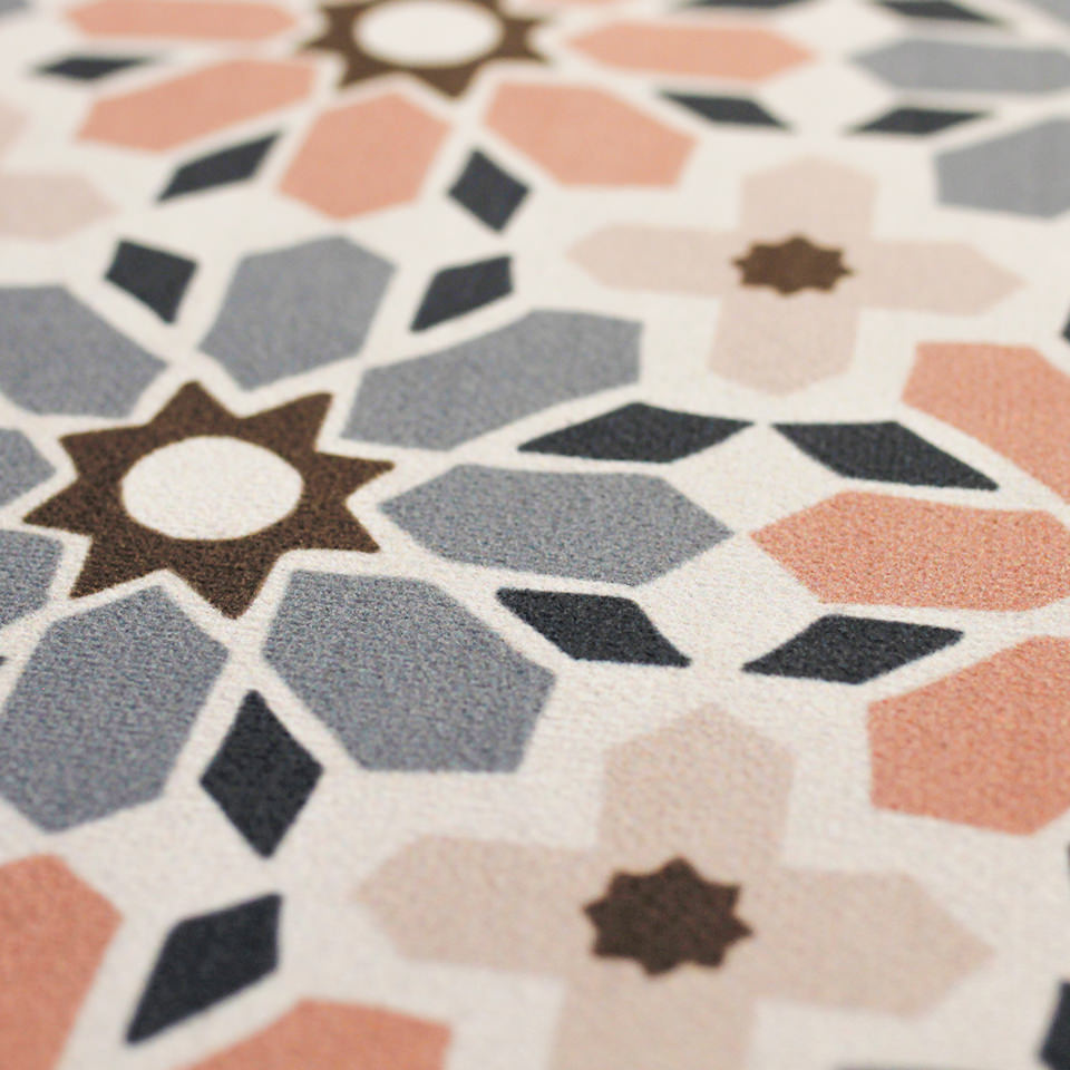Close up of printed moroccan tiled low profile indoor floor mat in pinks, blues, and beige
