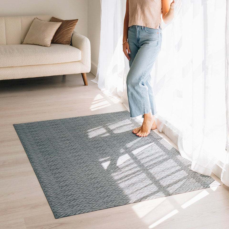 Woman standing on her Color Washed Quill Un-Rug mat that is located in her living room.