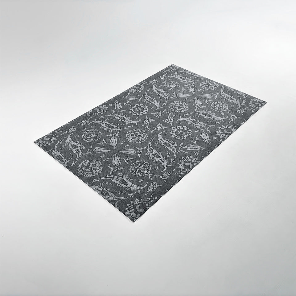 Angled image of Un-Rug's Filigree Floral mat in the size small with a floral design.