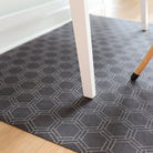 Close up of Un-Rug Honeycomb urbane bronze soft, felt surface and low-profile, perfectly placed under a desk.