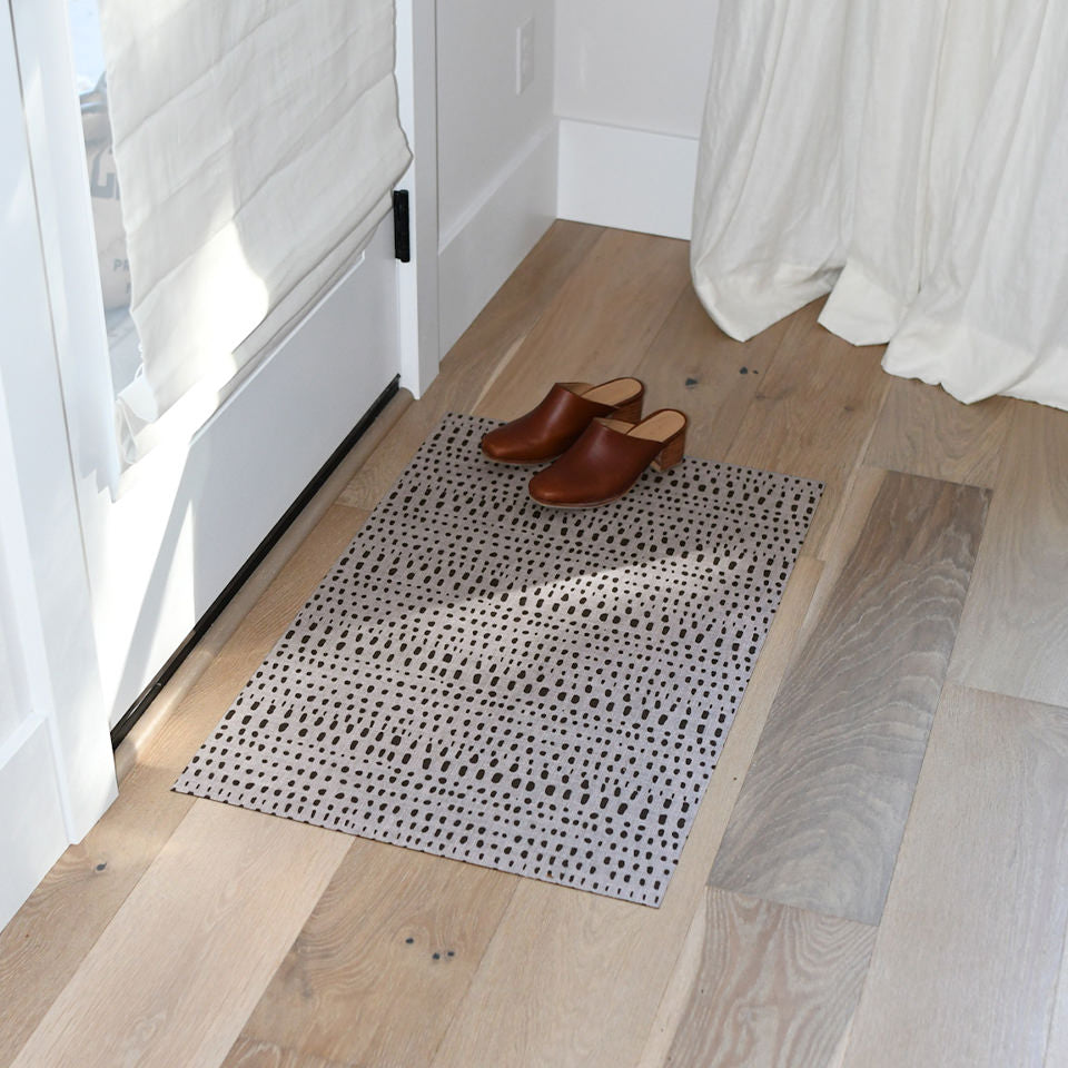 Small Indigenous Dots Un-Rug at the front door of a home with a pair of cute, brown heels resting on top of the mat