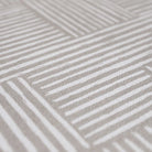 Close up view of Shiitake tan background with snowbound cream colored organic lines in abstract square pattern on a low profile washable interior floor mat.