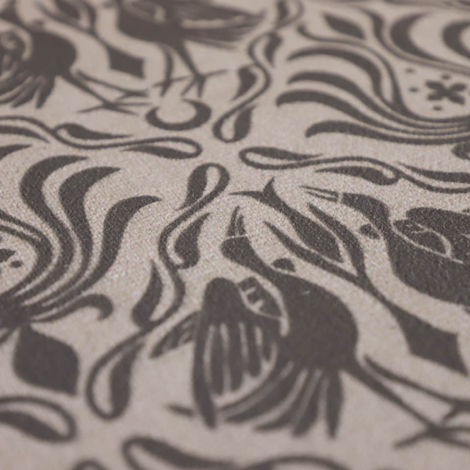 Close up of Urbane bronze ornamental cranes in a vintage damask looking pattern printed on shiitake tan background on a washable low profile indoor floor mat