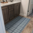 Un-Rug Oxford Plaid sea salt blue linen texture with storm cloud blue plaid stripes located in a bathroom in front of the vanity.