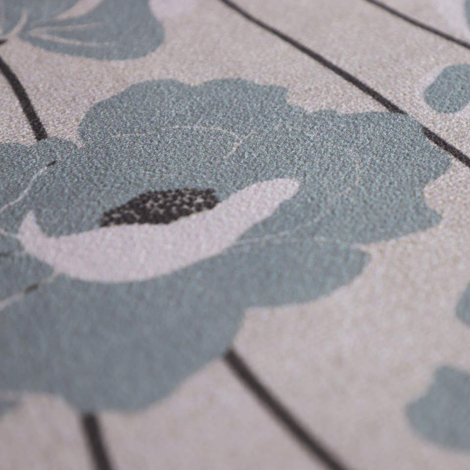 close up of soft fabric surface with beige/neutral background and blue/grey poppies with black stems 