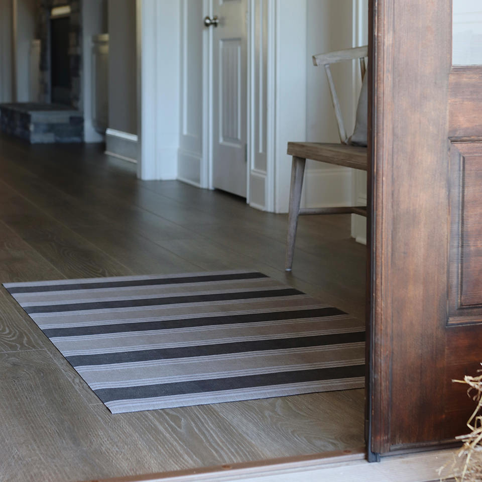 Un-Rug Ticking Stripes in a corridor protectng floors with its low-profile, full rubber backing, and machine washable construction.