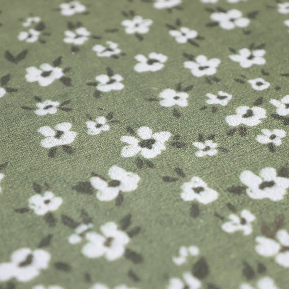 close up of green soft-knitted fabric with tiny white flowers