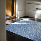 Dreamy picture of Un-Rug Tiny Flowers in  sea salt blue, with its low-profile and and rubber backed construction.