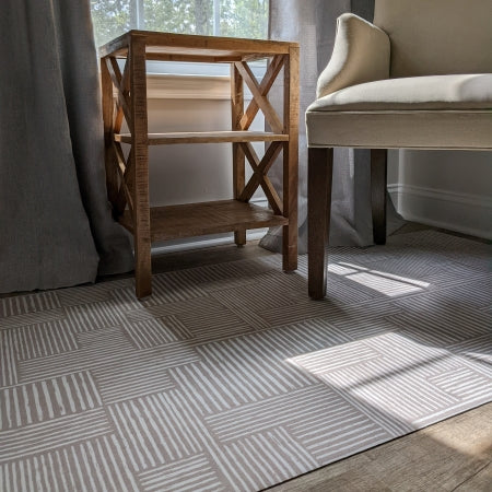 Reading chair and coffee table sitting on low-profile Un-Rug decorative mat with modern design.