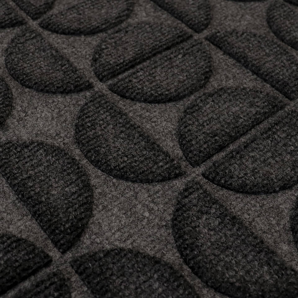 Detailed shot of Hourglass' bi-level surface and semi-oval alternating pattern in graphite; all-weather outdoor mat