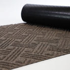 Greige WaterHog Luxe classic thatch doormat with corner rolled over showing rubber slip-resistant backing.