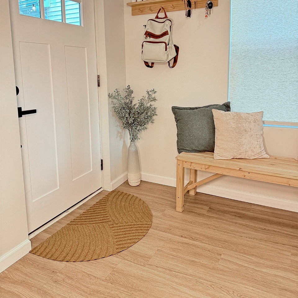 Half-round Heartland doormat in the color wheat inside a front door for all-weather floor protection.