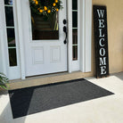 WaterHog Luxe large mat in charcoal at the front font door of a home.