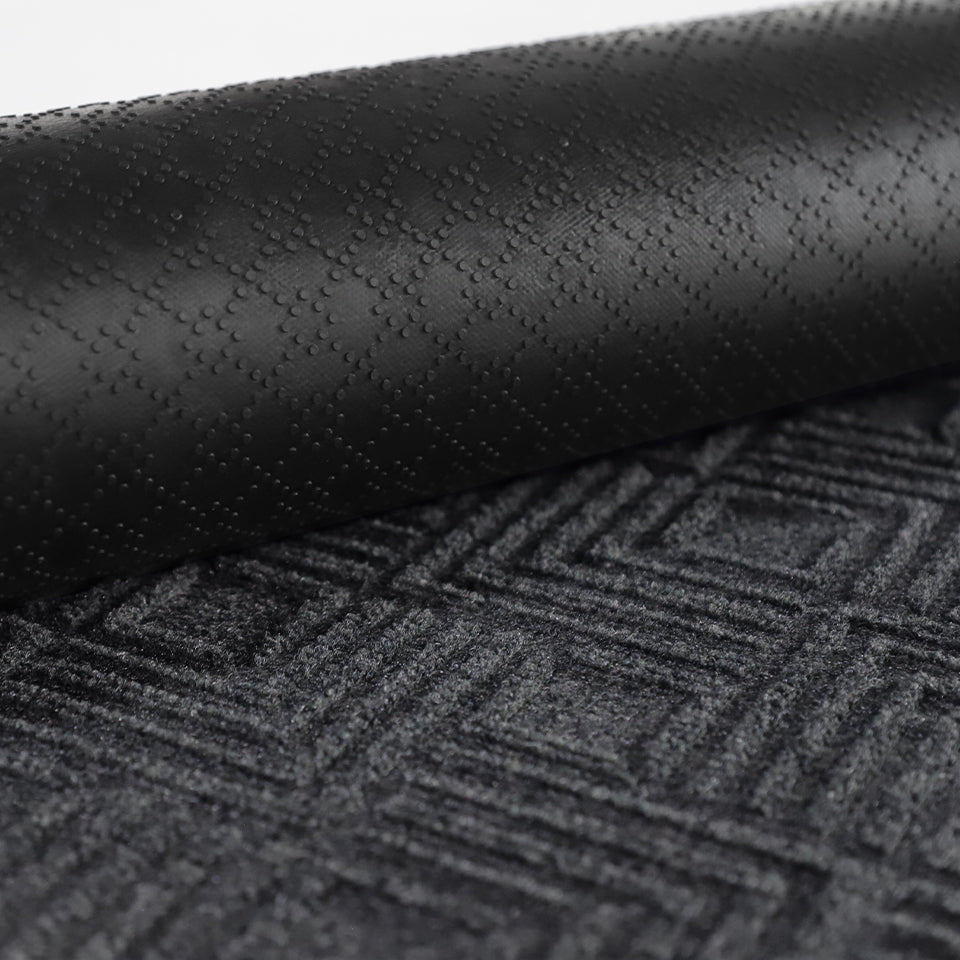 A close-up image of the all-weather Labyrinth mat half rolled showing both the rubber backing and graphite surface.